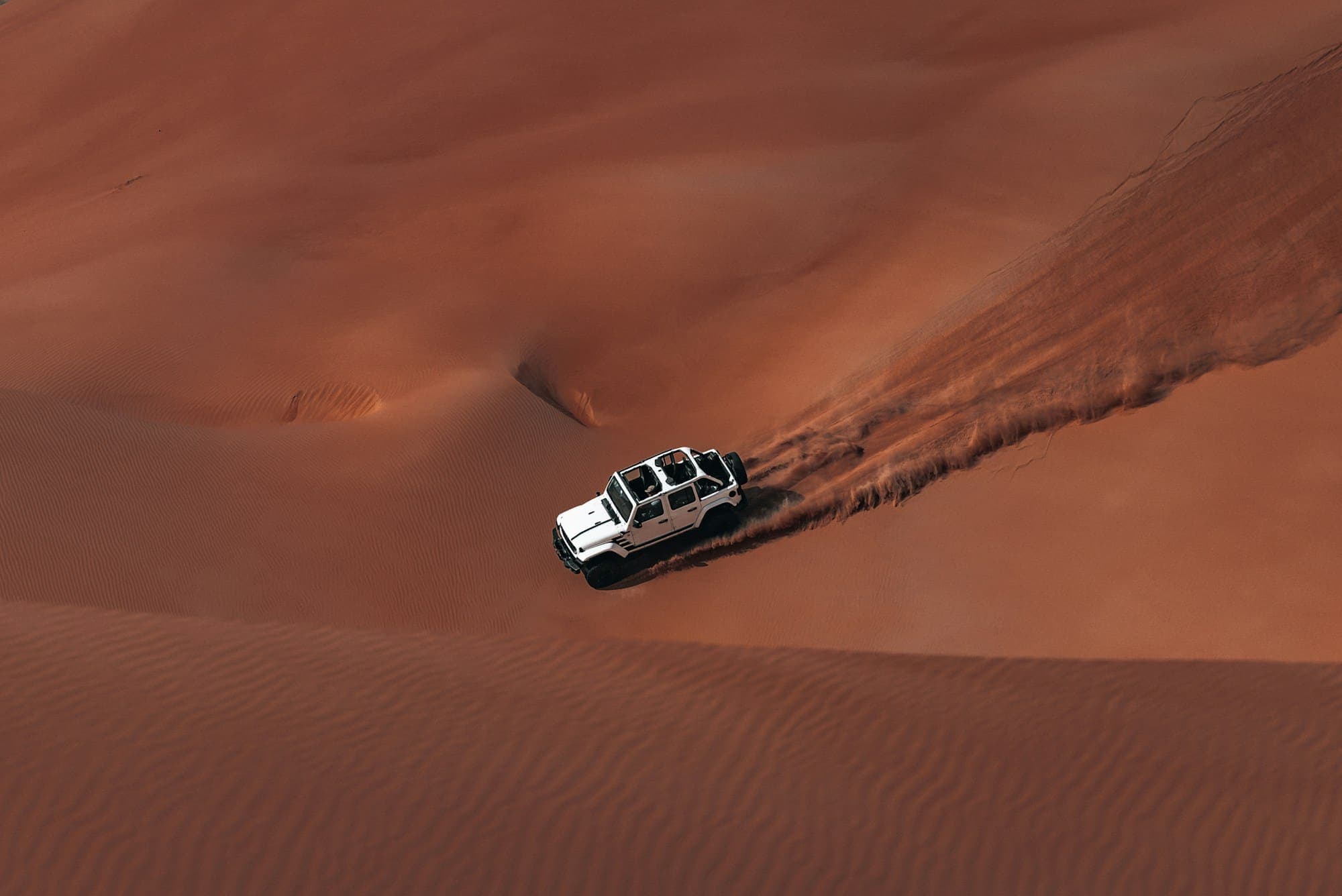 4x4 driving over golden sand dunes